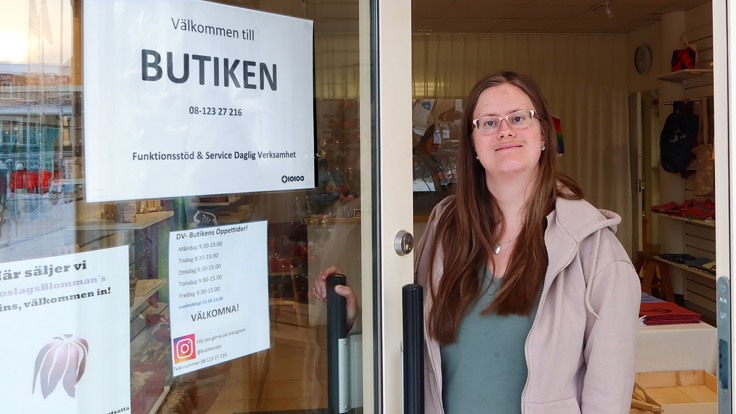 Tjej/deltagare står i den öppna butiksdörren