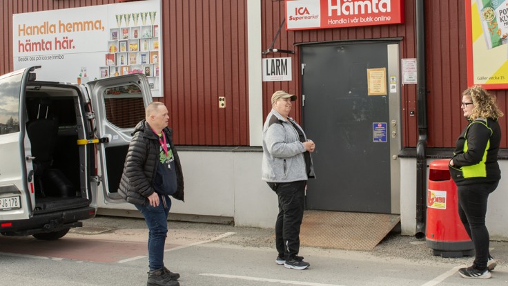 Deltagare och personal står och väntar utanför Ica-butik